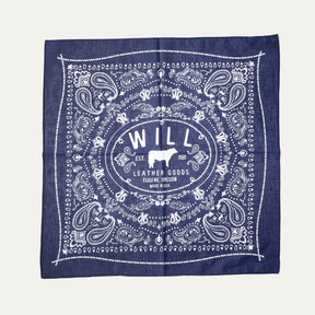 Will's Bandana in navy blue paisley print, laid flat showing the center WILL Leather Goods cattle-brand logo, on a white background.