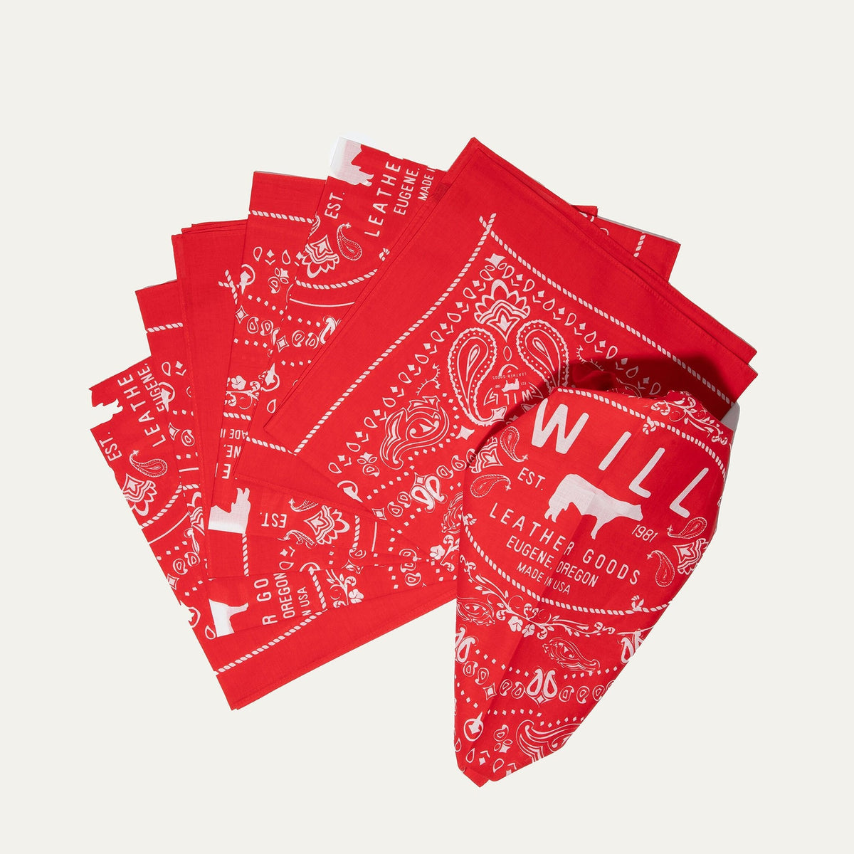 Several red paisley Will's Bandanas fanned out to show the folded stack and logo corner detail.