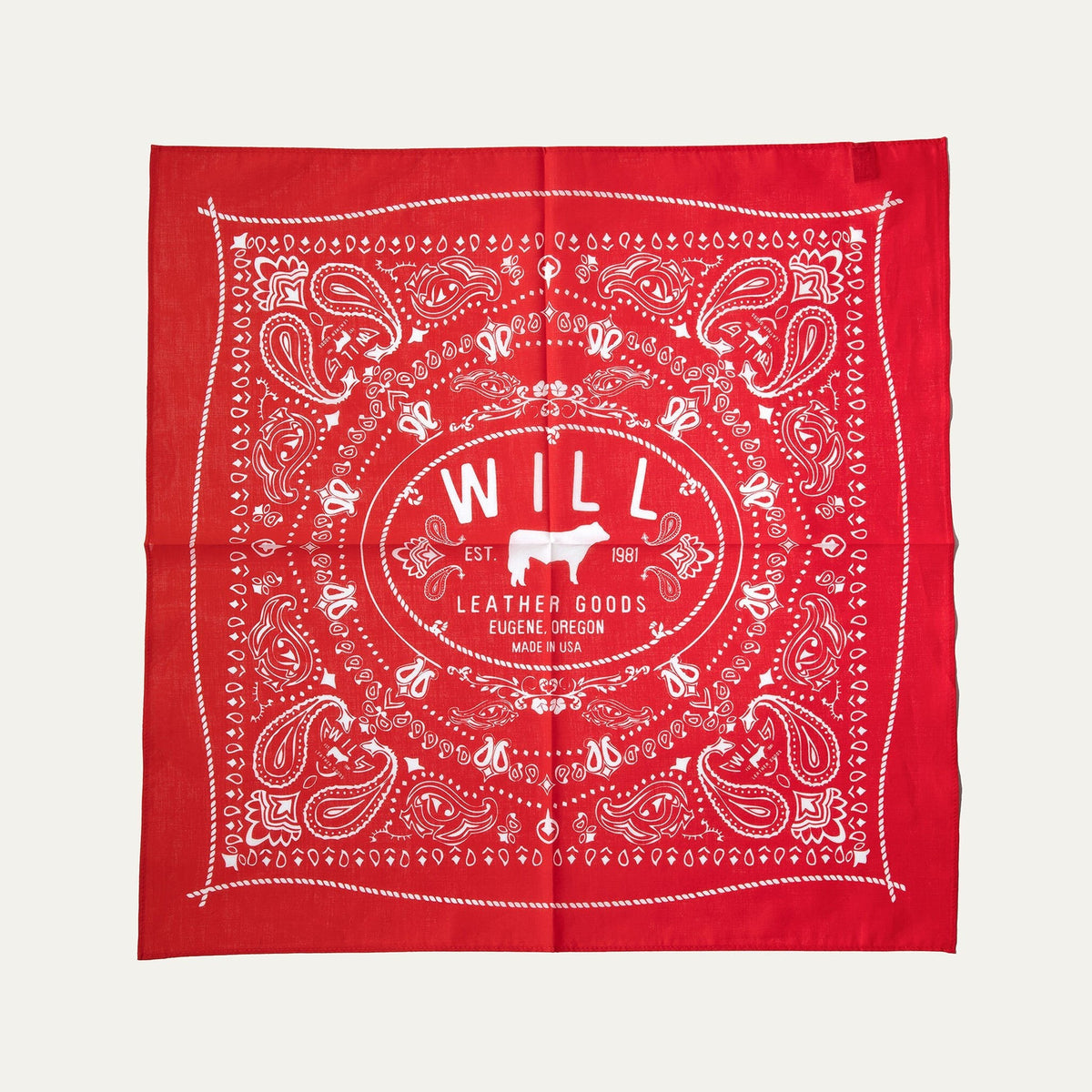 Will's Bandana in red paisley print, laid flat showing the center WILL Leather Goods cattle-brand logo, on a white background.