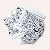 Several white and black paisley Will's Bandanas fanned out to show the folded stack and logo corner detail.