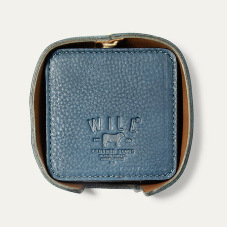 Open round leather holder for the Set of Eight Coasters in slate blue pebbled leather, showing the embossed WILL logo, on a white background.