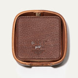 Will Leather Goods Set of Eight Coasters in brown pebbled leather, shown stacked inside the open round leather holder with embossed WILL logo, on a white background.