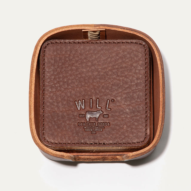 Will Leather Goods Set of Eight Coasters in brown pebbled leather, shown stacked inside the open round leather holder with embossed WILL logo, on a white background.