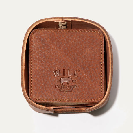 Open round leather holder for the Set of Eight Coasters in tan pebbled leather, showing the embossed WILL logo, on a white background.