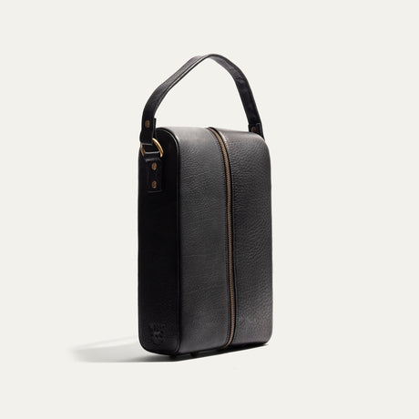 Will Leather Goods Hard Double Leather Wine Case in black pebbled leather, three-quarter angled view showing the carry handle, zipper pull, and embossed WILL logo patch.
