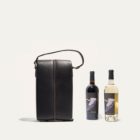 Will Leather Goods Hard Double Leather Wine Case in black leather shown closed and upright next to a red wine bottle and a white wine bottle for size comparison.
