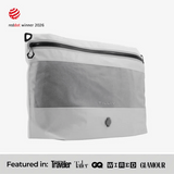 TILLIV Compak Large in Digital White seen at an angle, above a strip reading Featured in Conde Nast Traveler, Tatler, GQ, WIRED and GLAMOUR
