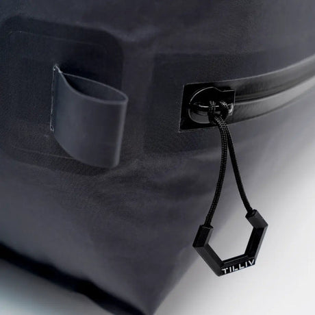 Close-up of the hexagonal TILLIV zipper pull and cord on the corner of the Kamper vacuum pack, beside an anchor loop