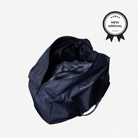 Navy TILLIV Pakke duffel opened from above with the Kamper vacuum pack inside, carrying a New Arrival badge