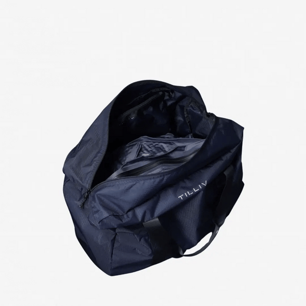 Navy TILLIV Pakke duffel opened from above, showing the grey Kamper vacuum pack fitted inside